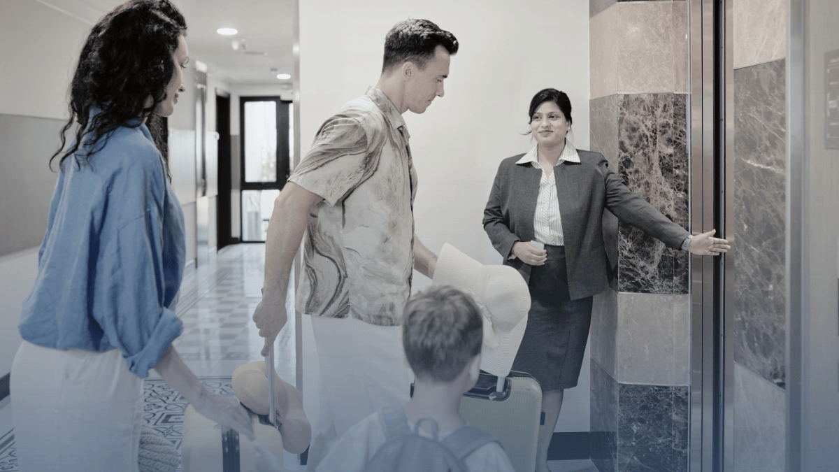 Parents and their children walking into a hotel elevator with their luggage.
