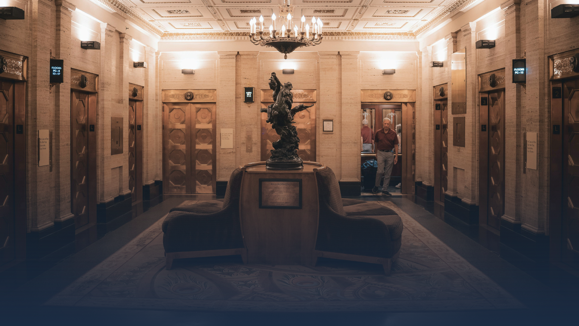A man walks into an elevator lobby that has been modernized while maintaining the art deco aesthetics of the building.