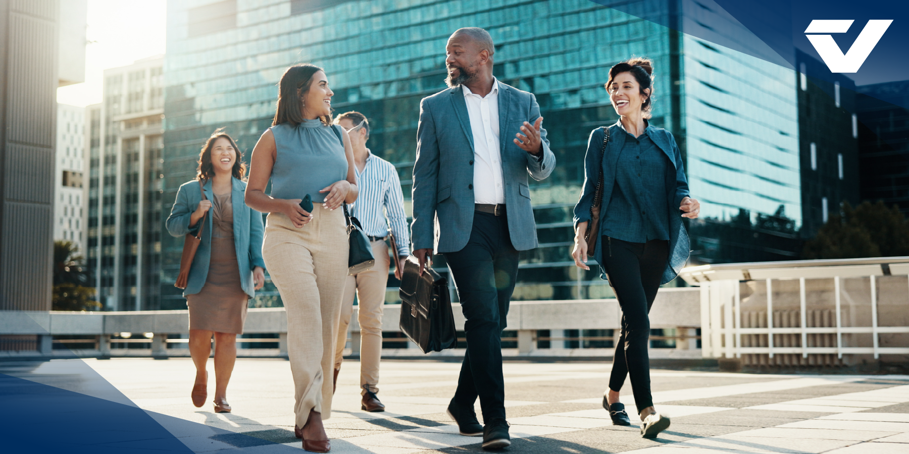 A property management team and their elevator consultant walking together and talking amid tall buildings.